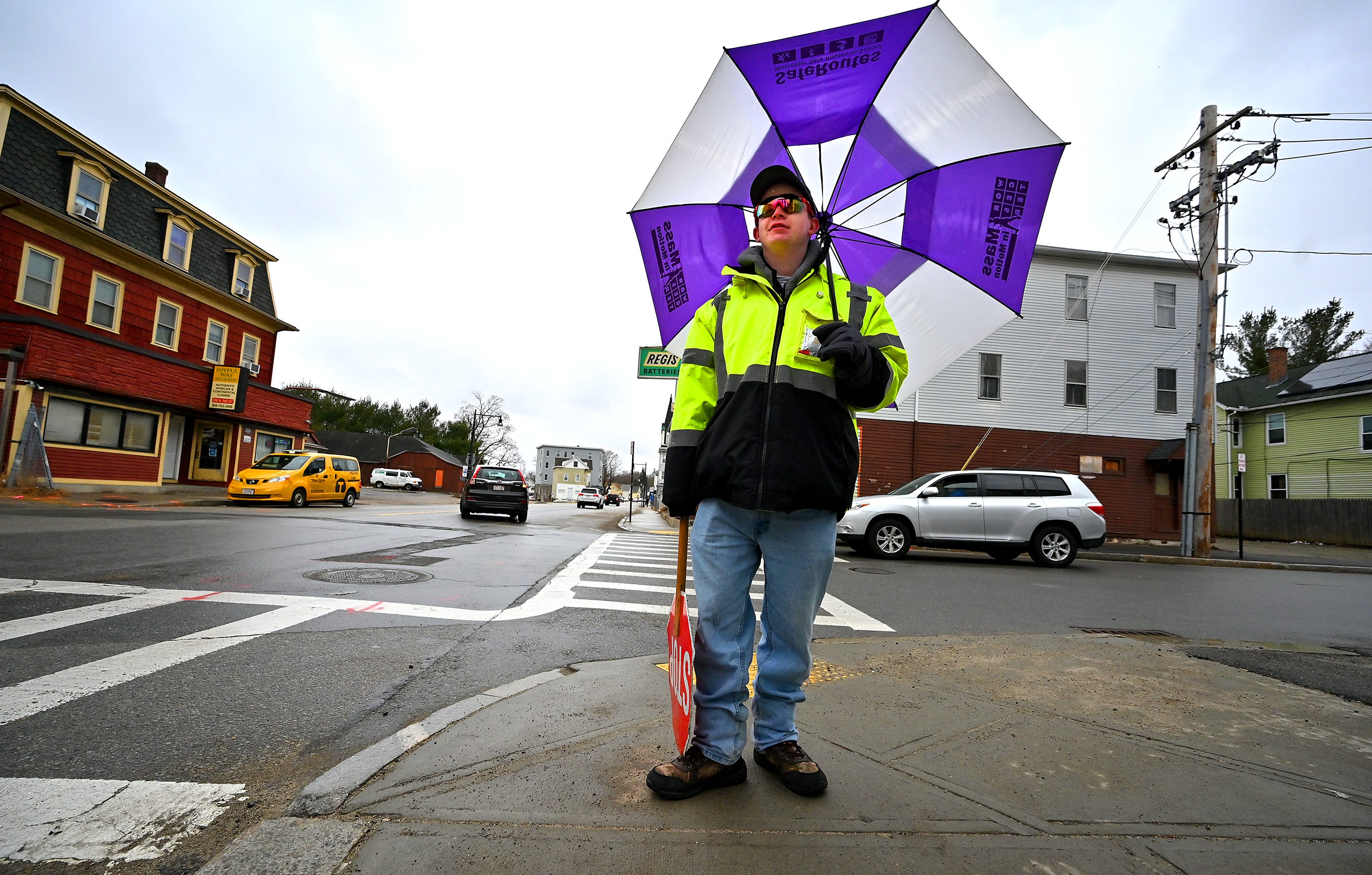 WORCESTER - As the nor'easter begins with bands of rain on Monday afternoon, school crossing guard Tyler Simoncini of Worcester waits for Quinsigamond School students to aid in crosssing Greenwood and Whipple streets.