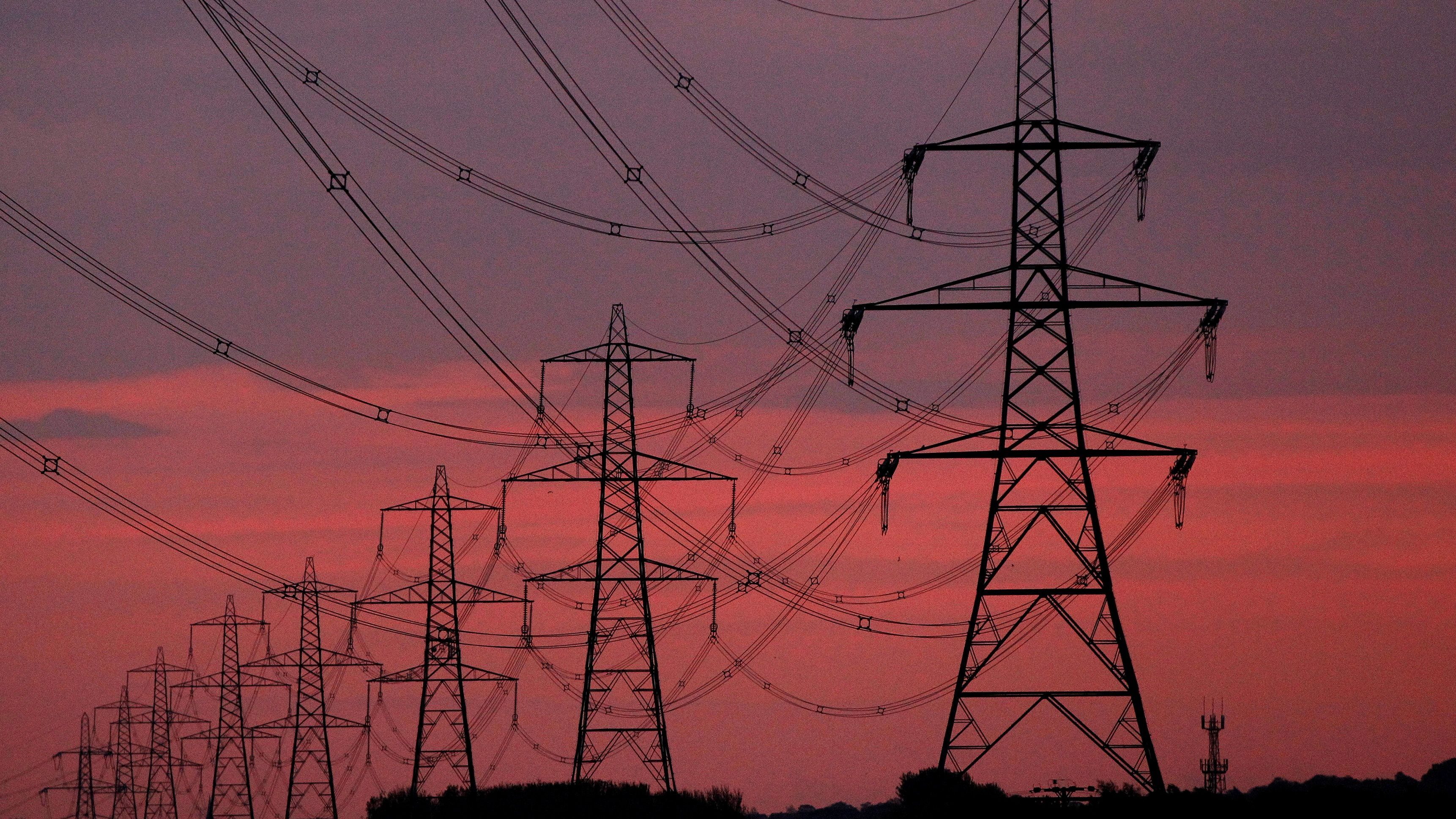 The sun rises behind electricity pylons near Chester, northern England.