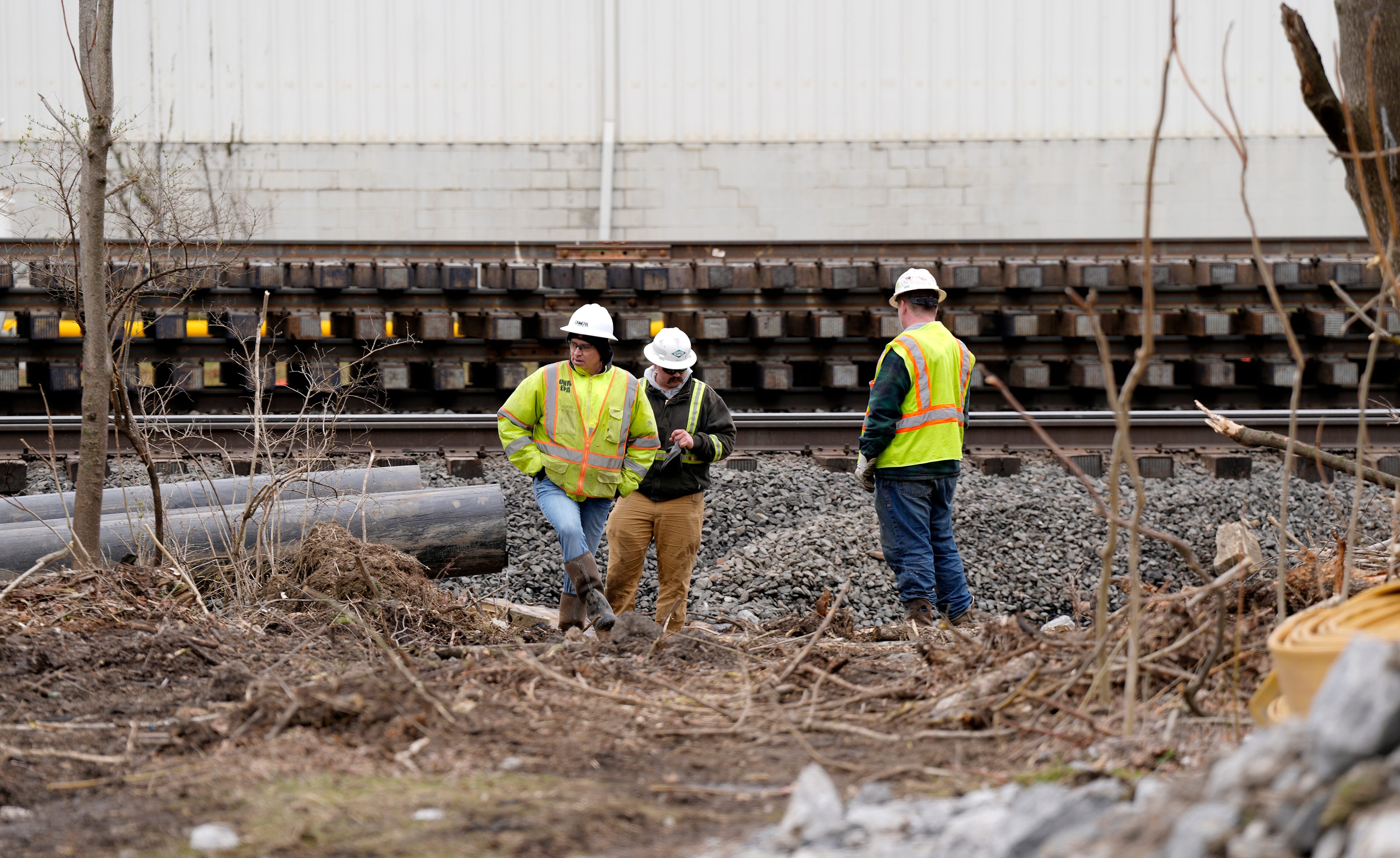 Crews work walk near the railroad track in East Palestine Wednesday, March 22, 2023, after a train derailed February 3. An overheated wheel bearing caused the dangerous derailment that spilled more than 100,000 gallons of toxic chemicals into the air and a fire burst into flames that night. The EPA says it could take up to three months to clean up. 